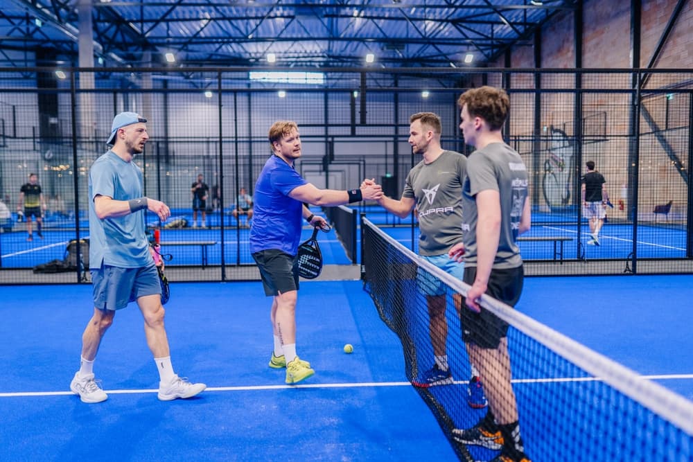 Joueurs de padel en plein match sur un terrain couvert